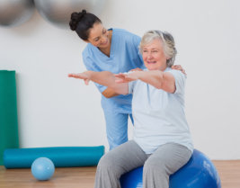 caregiver assisting senior woman on doing exercise